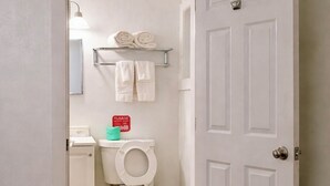 A bathroom with a toilet, a towel rack, and a toilet paper dispenser. - Relax Inn Smyrna Dover Coastal Gateway (Smyrna)