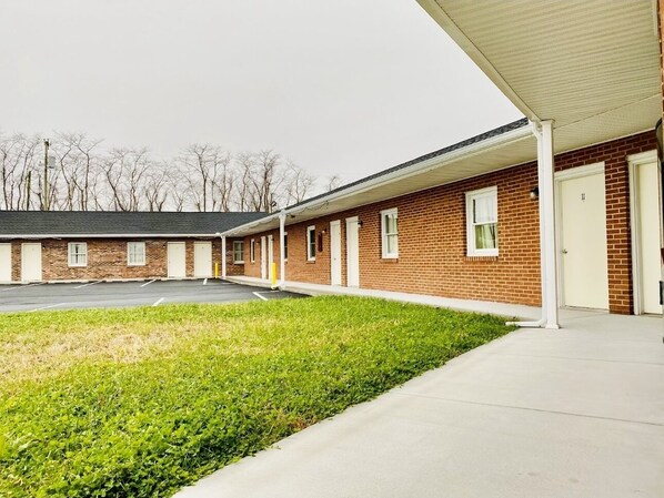 Guest rooms are nestled among single-story buildings with brick exteriors and white-framed windows.