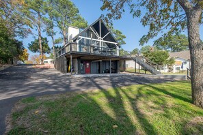 Un bâtiment à deux étages doté d’un balcon et d’un espace extérieur aménagé avec des sièges, protégé par un auvent.