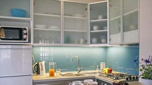 Eine moderne Küche mit Mikrowelle, Wasserkocher, Spüle und Gasherd.