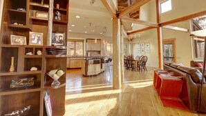 A spacious living area with wooden beams, a kitchen with a central island, and a cozy seating area with a leather couch.
