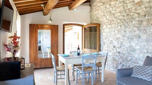 A dining area with a stone wall, wooden ceiling, and a table set for four.