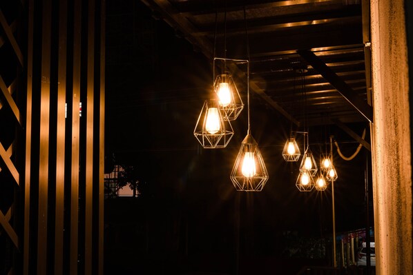 A series of hexagonal pendant lights hanging from a ceiling in a dimly lit interior space.