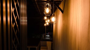 A narrow stairway with a metal railing, a tiled floor, and hanging light fixtures. - Hotel Naomi  (Bacalar)
