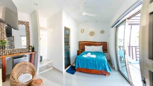 A modern bedroom with a large bed, a television, a desk, and a balcony. - Hotel Naomi  (Bacalar)