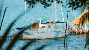 A boat named 'CHARTEMBL' docked at a pier with a thatched-roof structure nearby. - Hotel Naomi  (Bacalar)