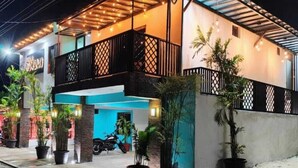 A two-story building with a balcony, potted plants, and a motorcycle parked in front. - Hotel Naomi  (Bacalar)