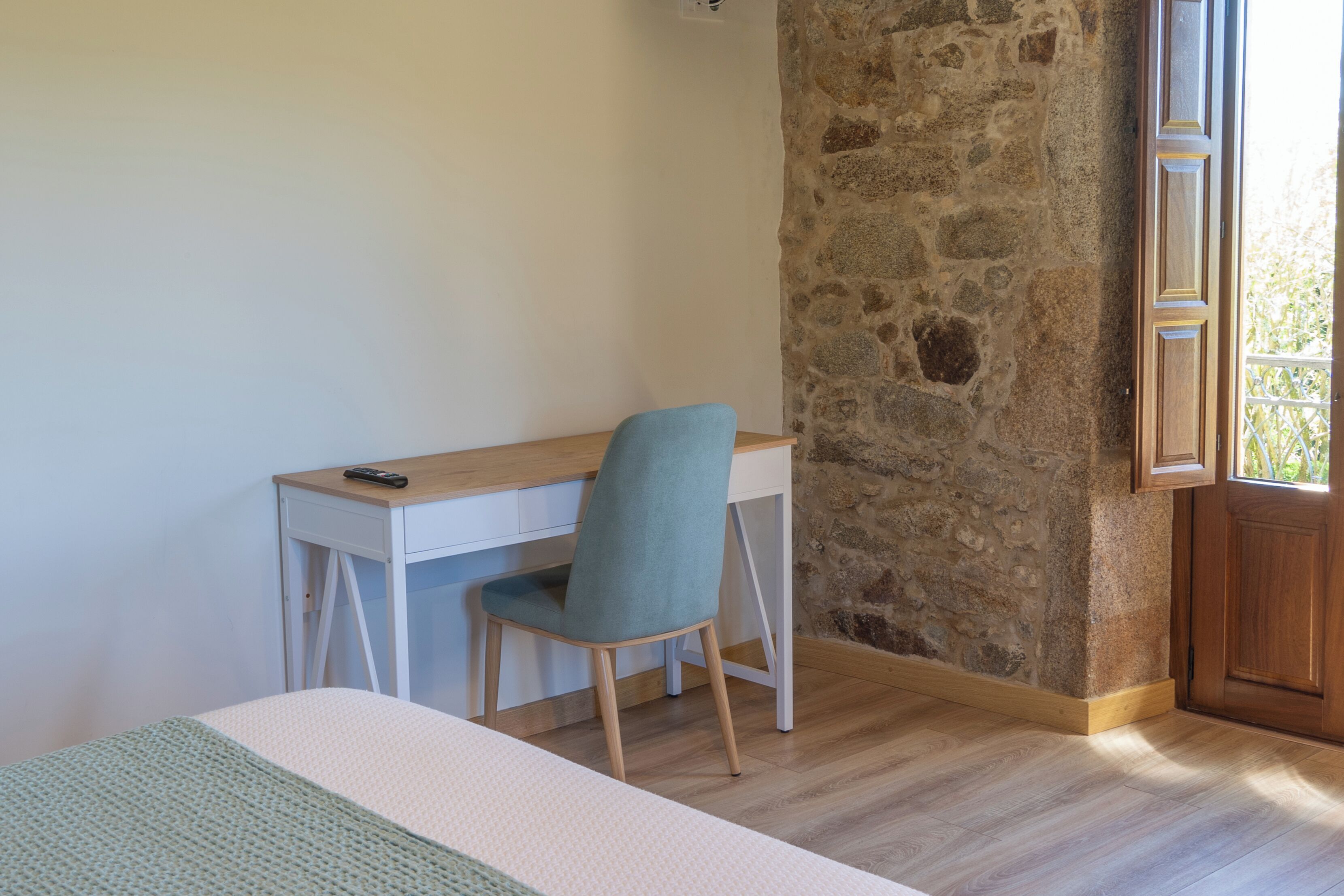 Un dormitorio con cama, escritorio y silla.