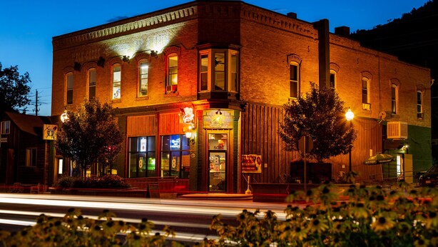 A historic building with a storefront, large windows, and a prominent entrance. - 1892 suite at Ore House Inn (New Castle)