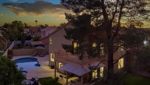 Una proprietà residenziale con piscina, area salotto all'aperto e patio coperto.