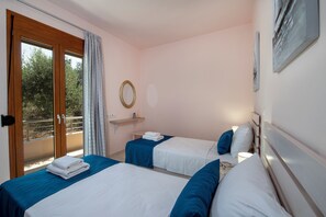 A hotel room with two beds, a balcony, a round mirror, and a painting on the wall. - Villa Amelia, modern and tasteful house in Cretan nature (Rethymno)