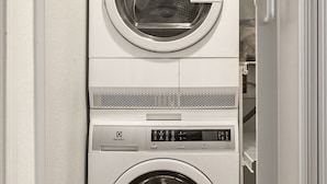 A stacked washer and dryer unit in a laundry room.