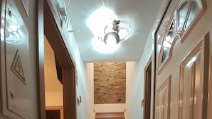 A hallway with a staircase, a fire extinguisher, and a ceiling light fixture. - Hostel Sertã (Serta)