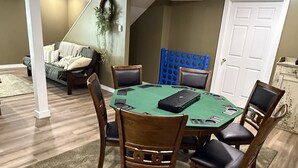 A room with a green pool table, wooden chairs, a sofa, and a white door. - gaze at Seneca Rocks from living room sofa (Seneca Rocks)