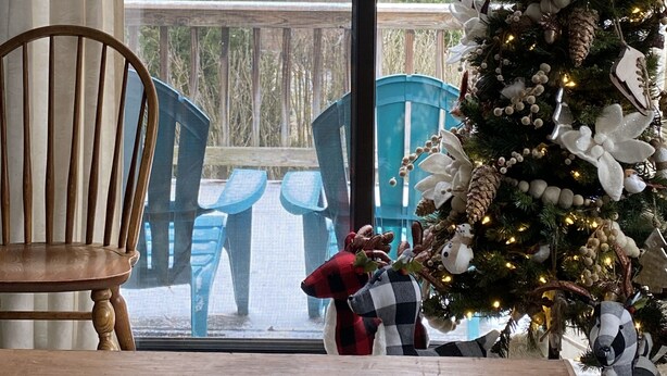 A room with a wooden table, a chair, and a Christmas tree with ornaments. - gaze at Seneca Rocks from living room sofa (Seneca Rocks)