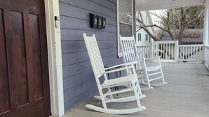 A porch with white rocking chairs and a mailbox labeled "ABC". - West End Jewel on Sunset (Winston-Salem)