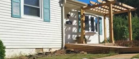 Una casa con una escalera de piedra que lleva a un porche de madera.