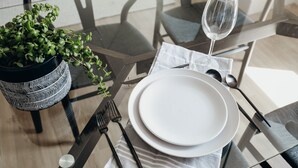 A dining table set with plates, cutlery, a glass of water, and a potted plant. - Proper Luxury, Sauna, The Woodland Loft (Bozeman)