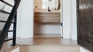 A wooden staircase leading to a bathroom with a wooden vanity and a mirror. - Proper Luxury, Sauna, The Woodland Loft (Bozeman)