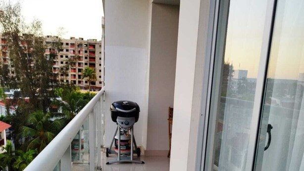 A balcony with a grill and a treadmill.
