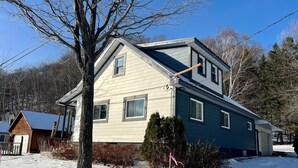 A two-story house with a gabled roof, a visible chimney, and a small porch area. - Munising Lakeview Getaway (Munising)
