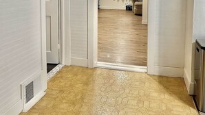 A hallway with a door leading to a living area, a ceiling fan, and a wall-mounted decorative item. - Munising Lakeview Getaway (Munising)