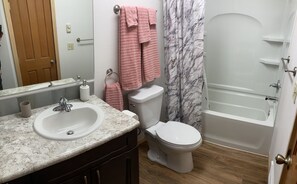 A bathroom with a sink, toilet, and bathtub.