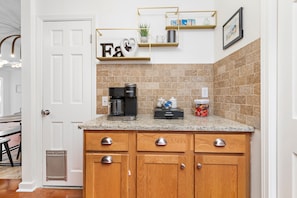 Kitchen features a granite countertop, wooden cabinets, and a brown tile backsplash.