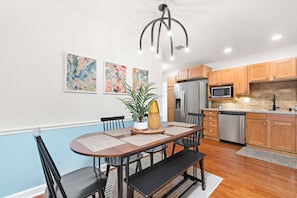 Enjoy meal preparation and dining at the central island with a sink, surrounded by cabinets and a refrigerator.