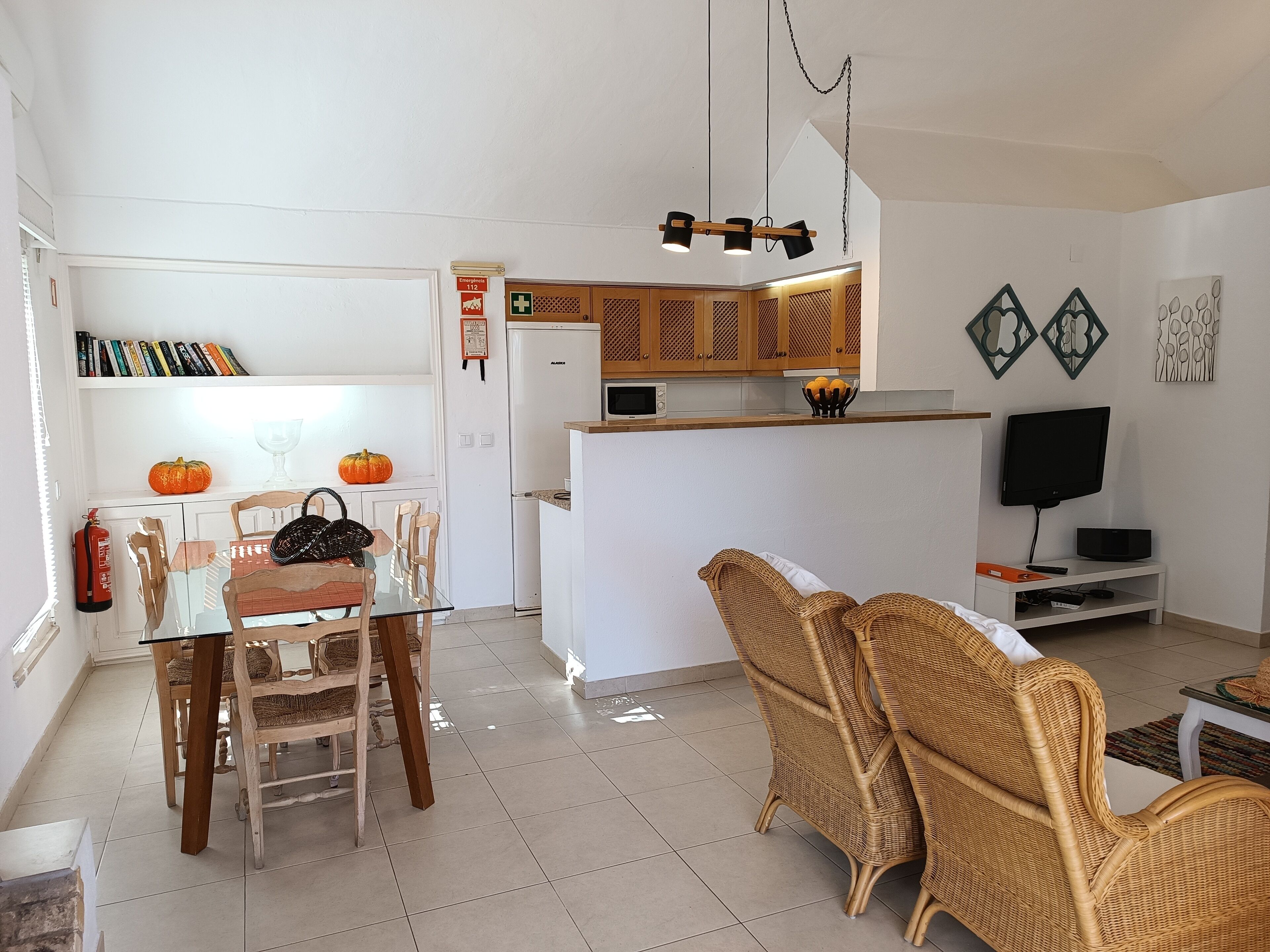 Een moderne woonkamer met een eethoek, keuken en televisie.