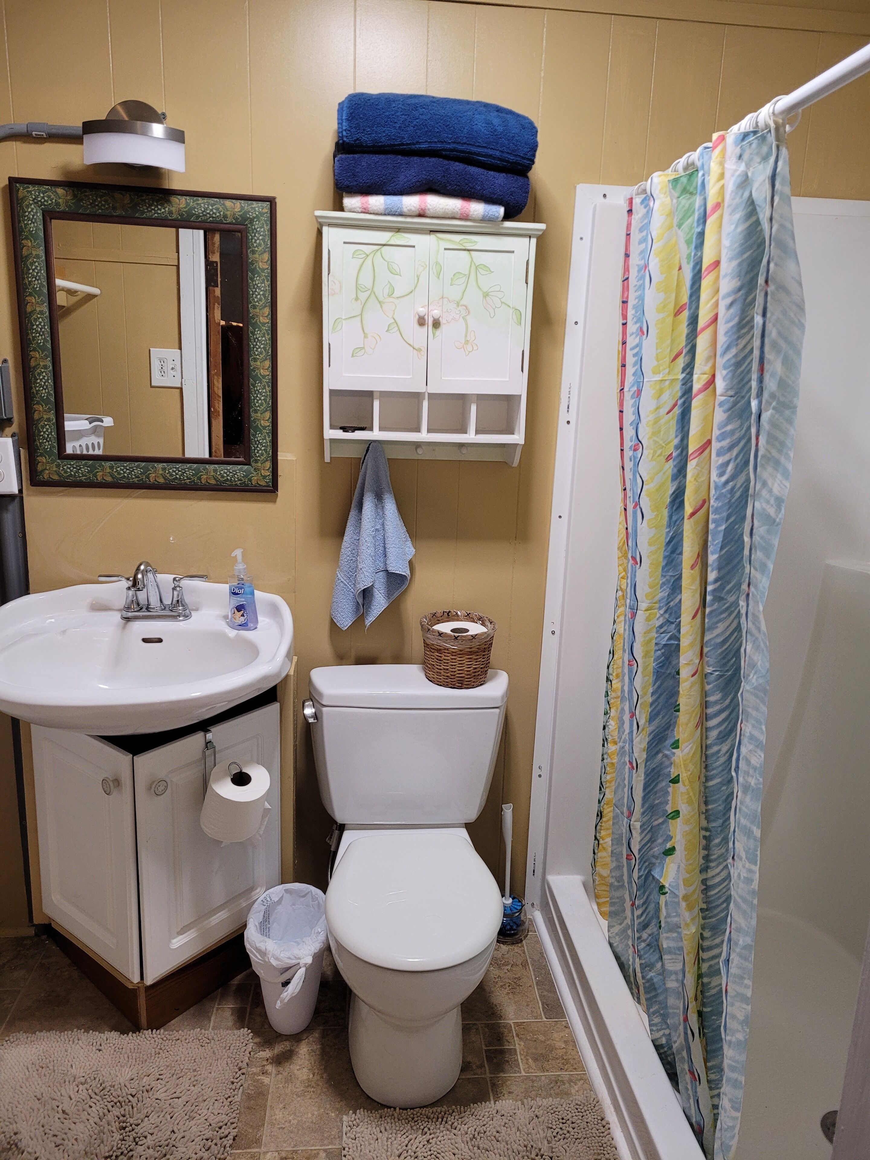 A bathroom with a sink, toilet, and shower curtain.
