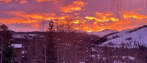 Un paisaje nevado con un atardecer.