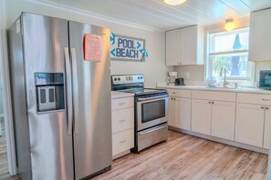 A kitchen with stainless steel appliances, a refrigerator, oven, and a coffee maker.