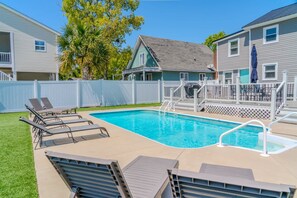 A swimming pool with a deck, lounge chairs, and a fenced area with a covered deck. - Duplex 705 18th Ave S- Unit A (North Myrtle Beach)