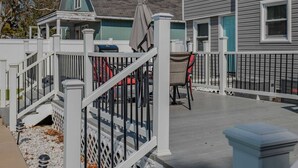 Une terrasse dotée d’une balustrade blanche, d’un espace salon couvert et d’une boîte aux lettres.