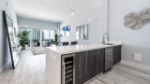 Una cucina moderna con una grande isola, mobili in legno scuro e lavastoviglie integrata.