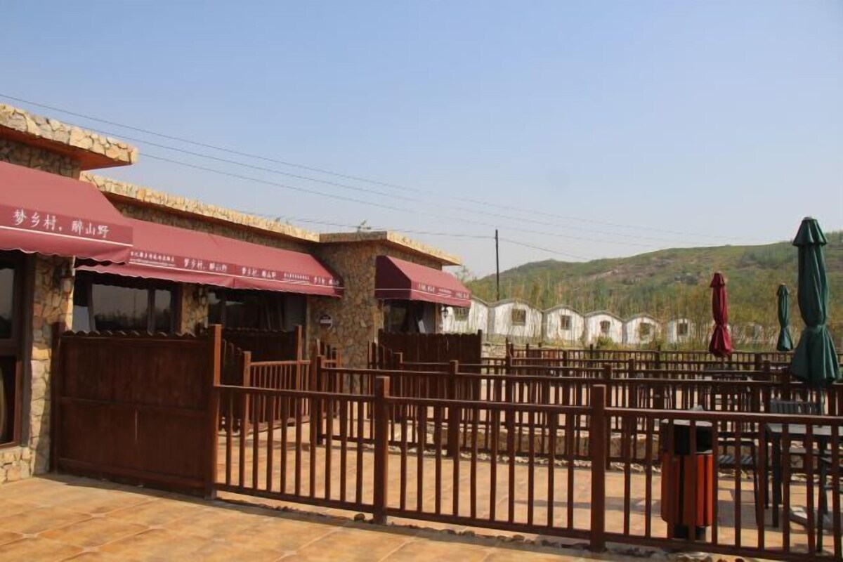 A rustic building with a stone facade and a red awning.