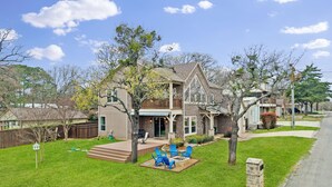 A two-story house with a front deck, a fire pit, and outdoor seating. - Miller's Cove on Lake Texoma! Luxury Lakeview Home! (Pottsboro)