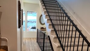 A modern staircase with a black railing leading to an upper floor.