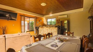 A cozy dining area with a wooden ceiling, a sofa, and a table set for a meal. - The Lake Village, La Fortuna de San Carlos (La fortuna)