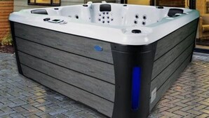 A spa hot tub with a wooden exterior and a blue accent on the side. - Steps away from the slopes!  Recently built Scandinavian Cabin with Jacuzzi! (Beaver)