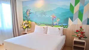 A hotel room with a large bed, a mural of a tropical landscape, and two nightstands with flower arrangements. - MaxOneHotels.com at Jayapura (Jayapura)