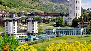 Ett hotellkomplex med flera byggnader, inklusive en hög, cylindrisk byggnad och ett antal rektangulära byggnader med balkonger.