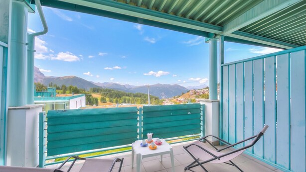 A balcony with a table and chairs, overlooking a mountainous landscape. - Teleo 115 Ski In - Ski Out 50m, Sestriere, Italy (Sestriere)