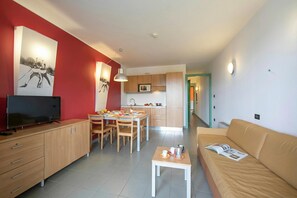 A modern apartment with a dining area, kitchen, and living space.
