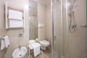 A modern bathroom with a glass-enclosed shower, a white sink, a toilet, and a towel rack.