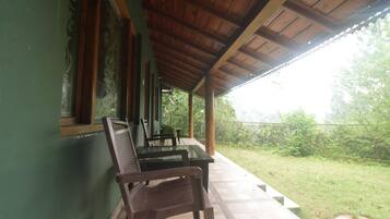 A covered patio with a wooden ceiling, a table, and two chairs.