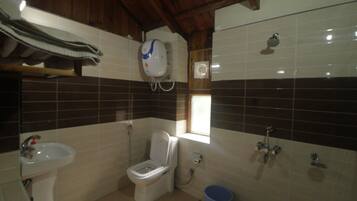 A compact bathroom with a toilet, sink, and shower.