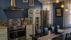 Eine moderne Küche mit Einbauofen, Edelstahl-Dunstabzugshaube und Essbereich mit Tisch und Stühlen.