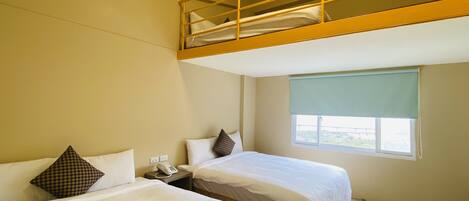 A hotel room with two beds, a bunk bed above, a bedside telephone, and a window with a view.